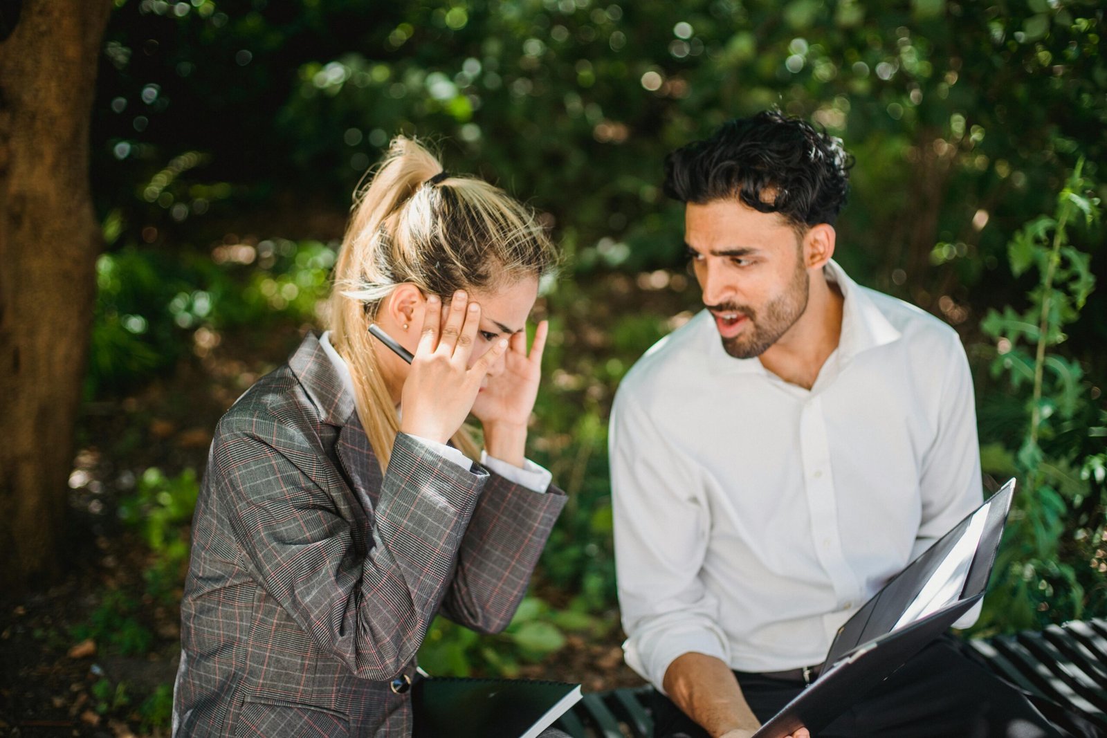 Two colleagues discuss business issues during an outdoor meeting.