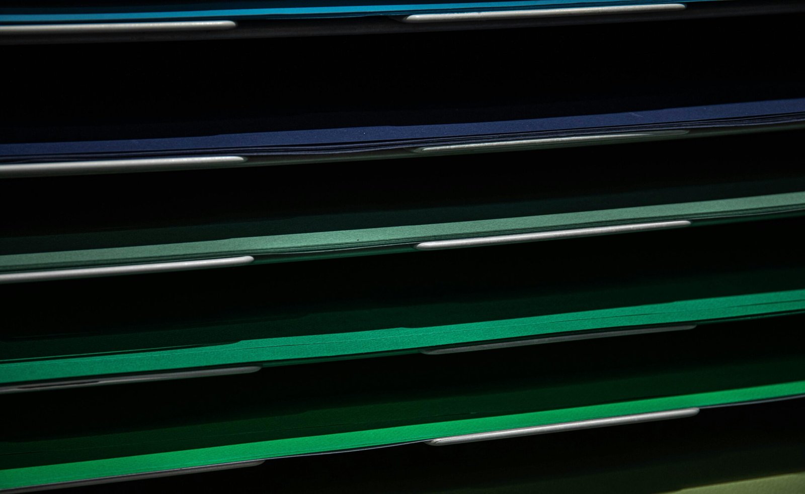 Close-up view of assorted colored paper in a stacking rack, perfect for school or office use.